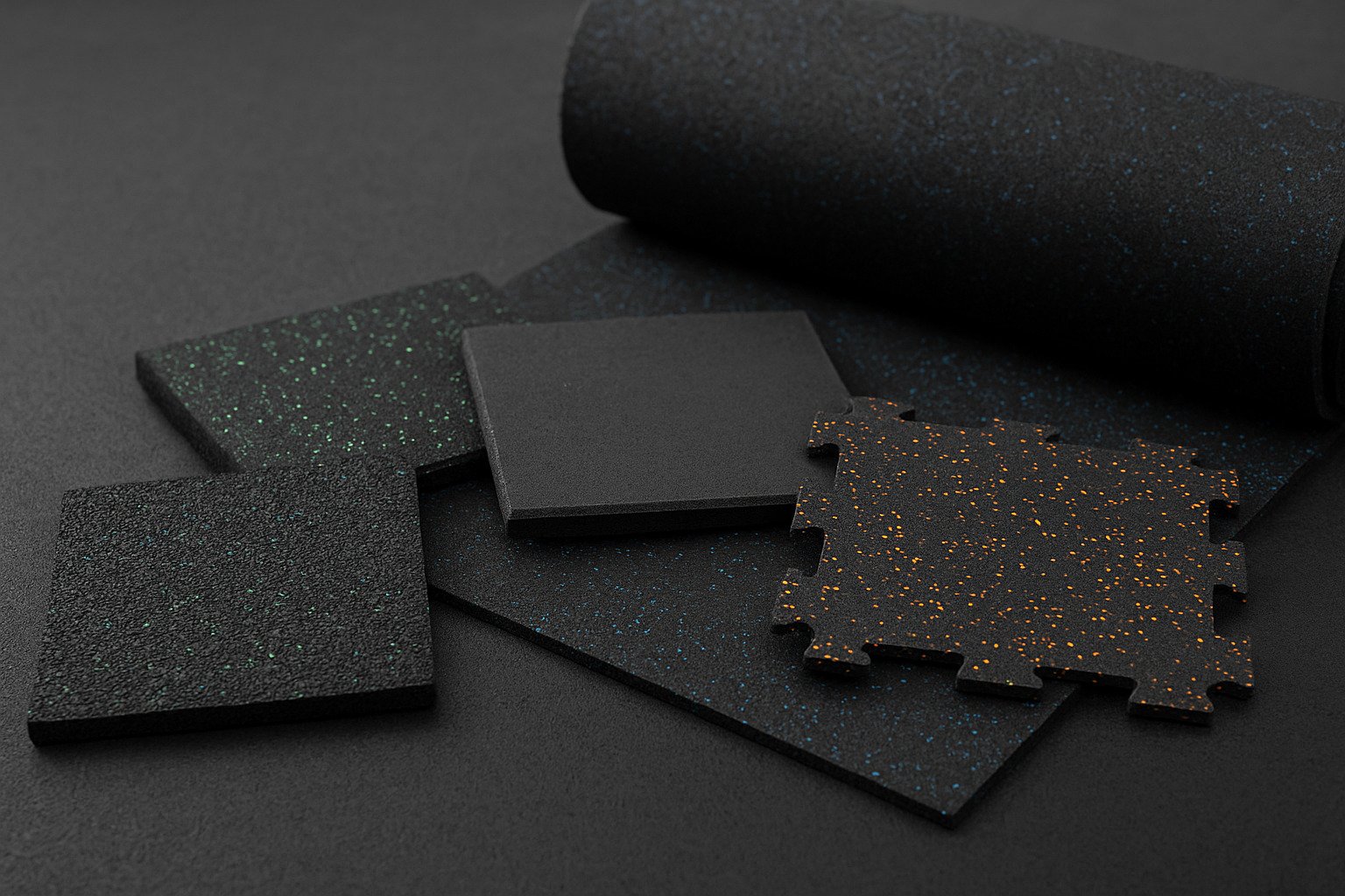Samples of rubber gym flooring including tiles and rolls, displayed on a dark surface