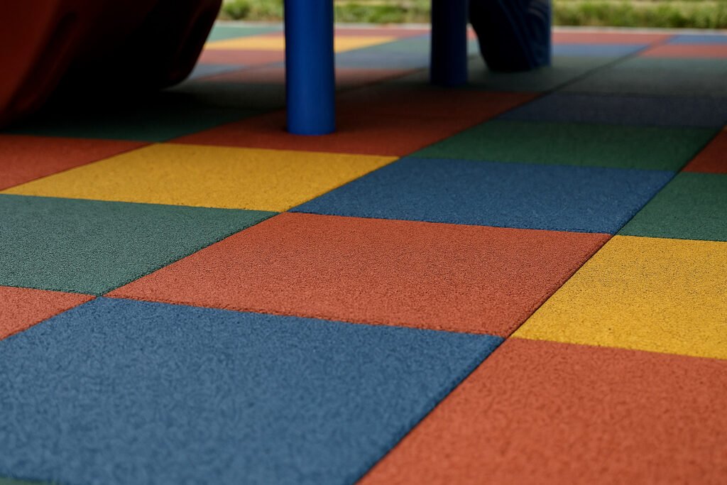 colorful interlocking rubber tiles installed in an outdoor playground for children