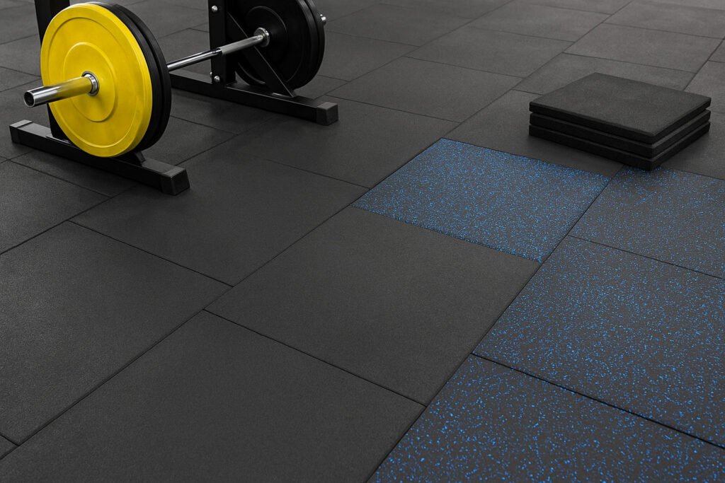 Gym with rubber flooring tiles and rolls installed in free weight and cardio zones